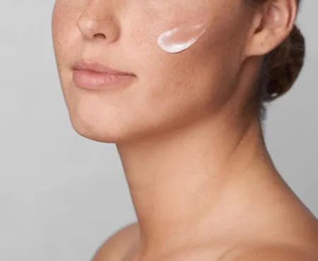 Nahaufnahme einer Wange mit großen Poren und Mitessern